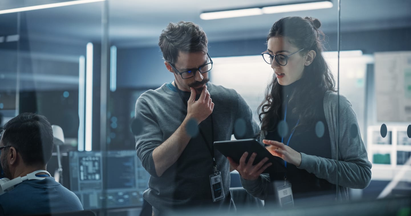 Researchers in an office looking at tablet